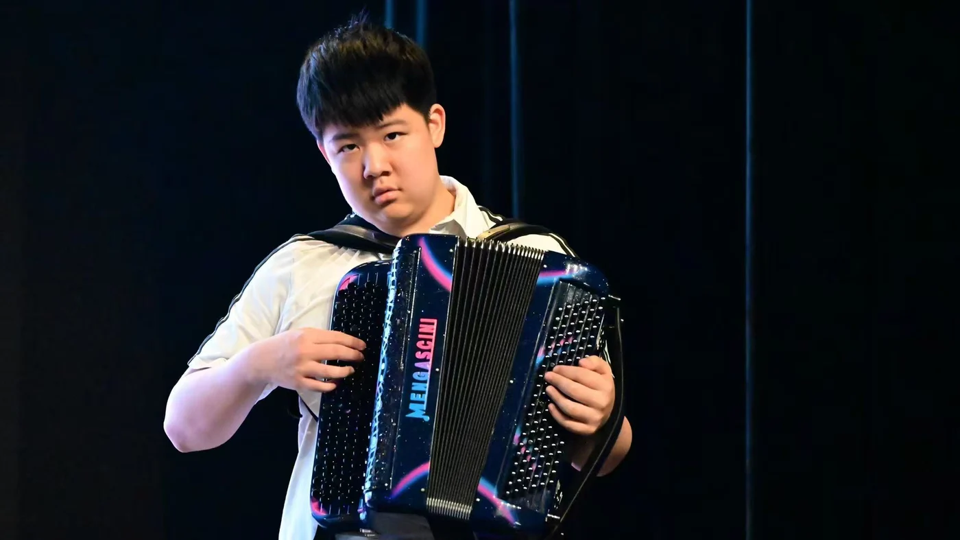 Shuran playing the accordion on stage